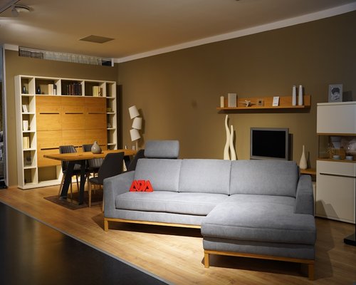 A relaxed modern living room environment with soft warm ambient lights glowing under shelves